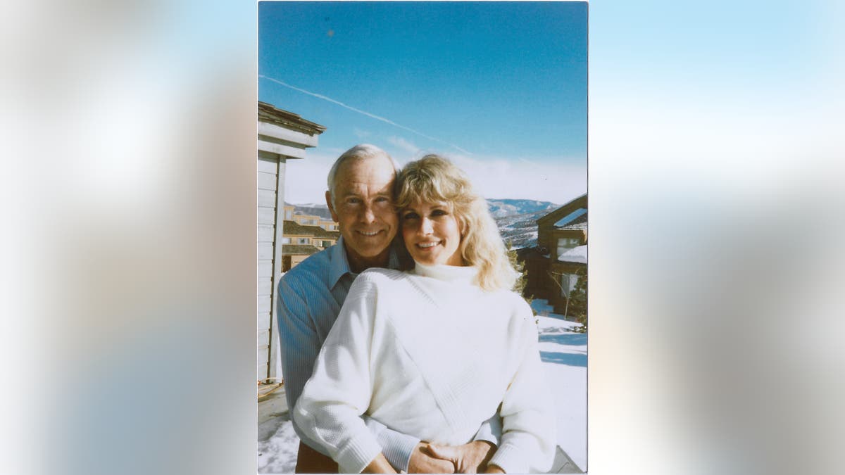 Alex con un suéter blanco con su esposo Johnny Carson con una camisa azul.