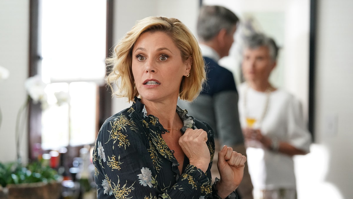 Julie Bowen looking surprised in a floral top.