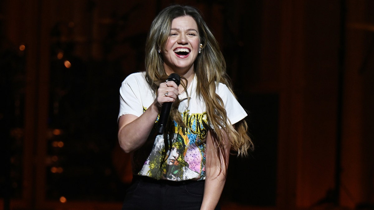 Kelly Clarkson on stage in a white shirt during her residency in Las Vegas.