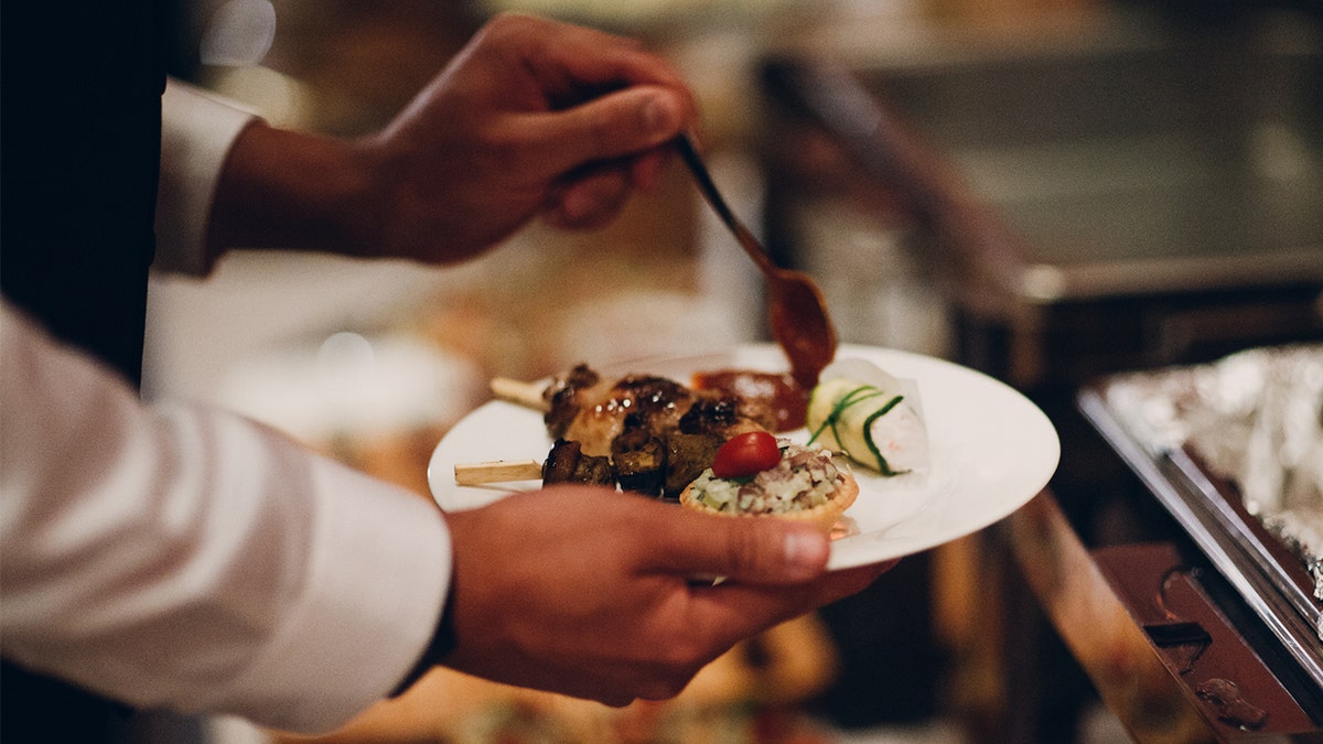 Man putting buffet food on plate