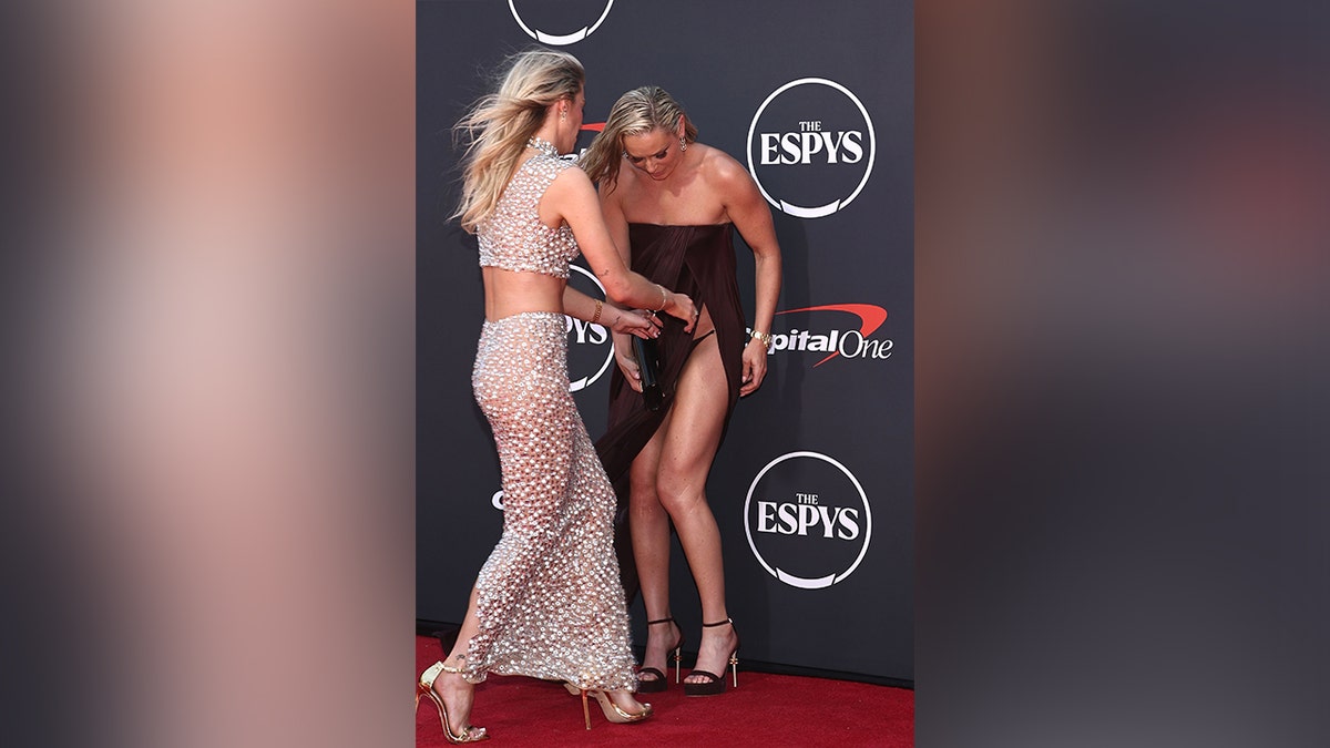 Lindsey Vonn and her sister fixing her dress while on the ESPYs red carpet.