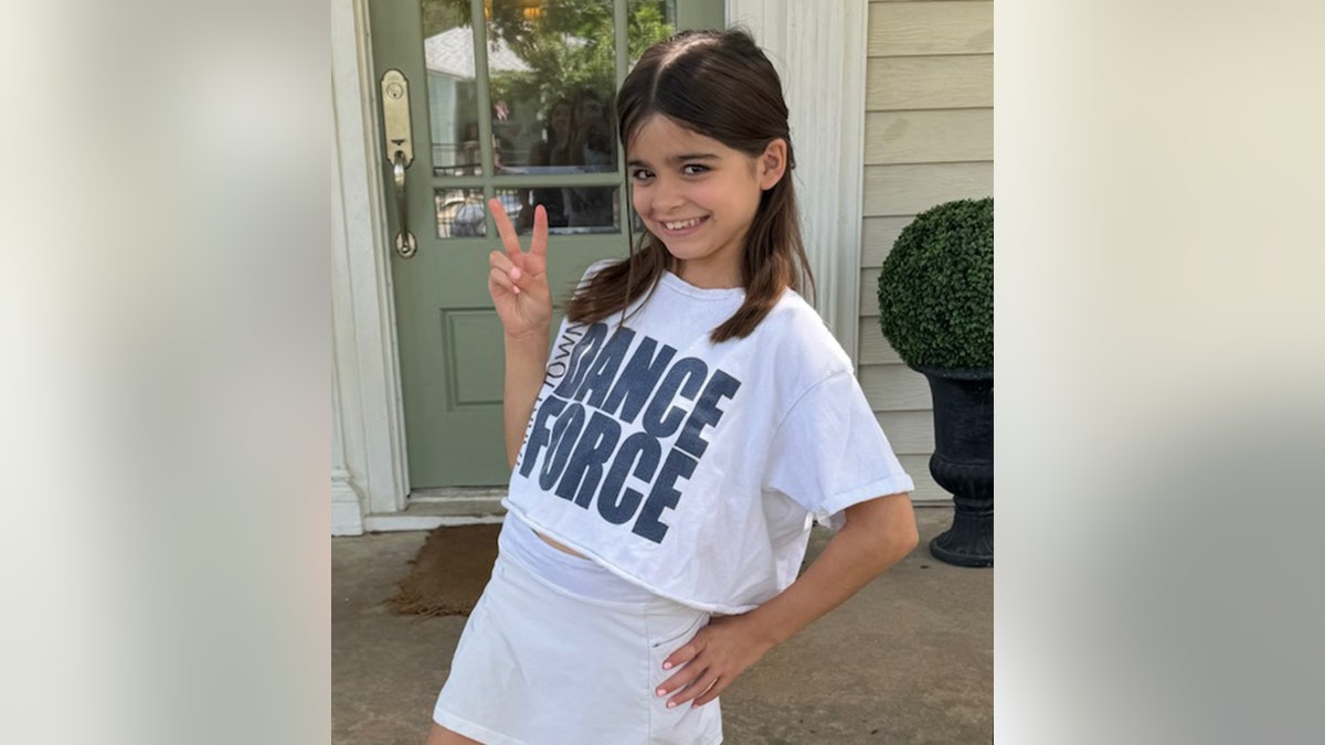 Linnie Anne McCown making a peace sign with one hand and smiling