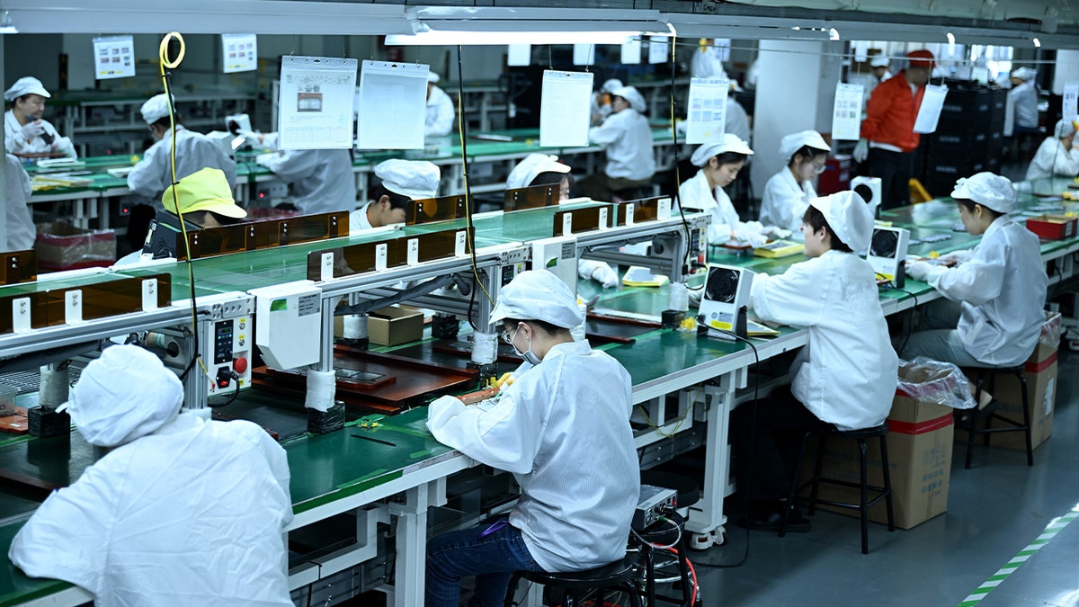 Workers manufacture lithium batteries for laptops in the workshop in Nantong City, Jiangsu Province, China, on June 23, 2025.