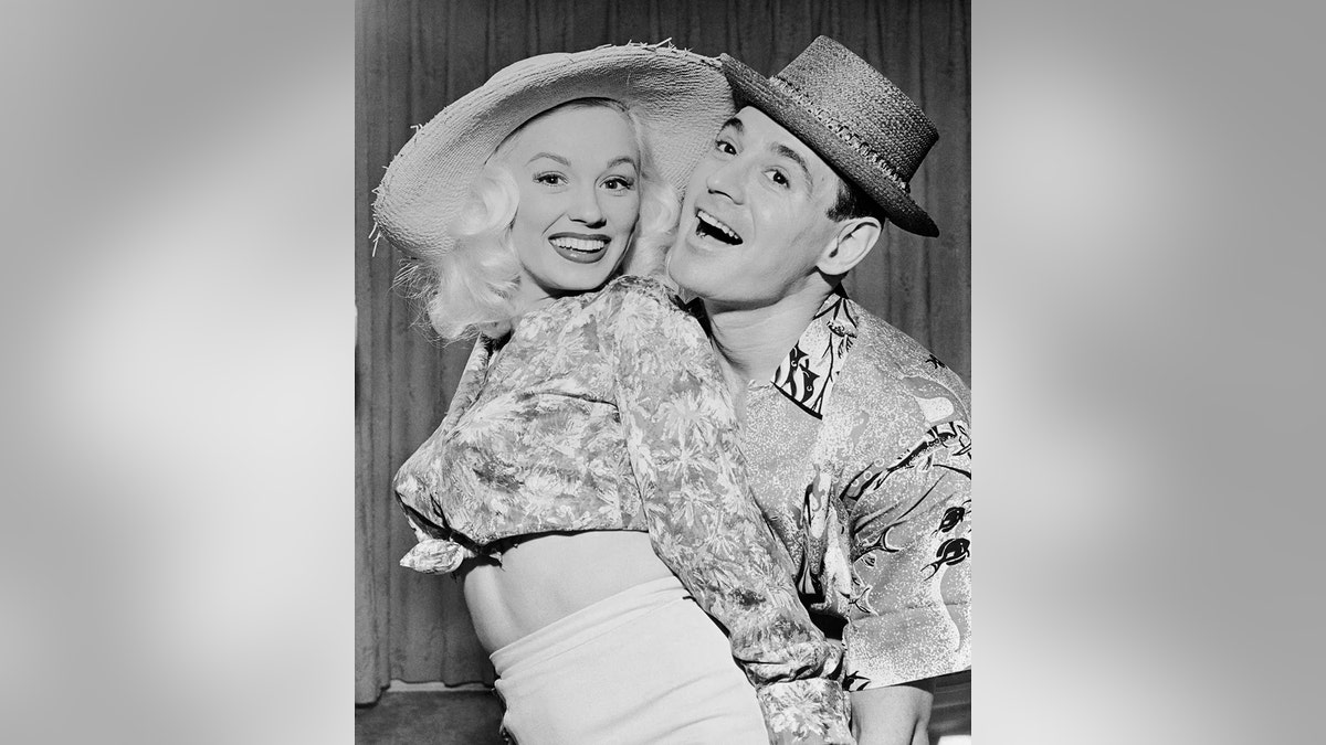 Mamie Van Doren smiling and happily dancing with her husband Ray Anthony.