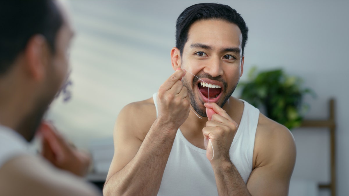 Man flossing in mirror