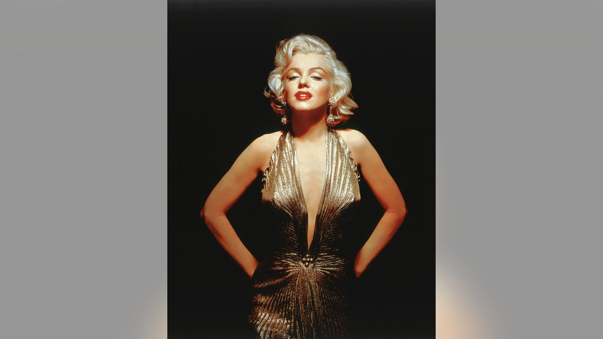 Marilyn Monroe wearing a low-cut gold dress.