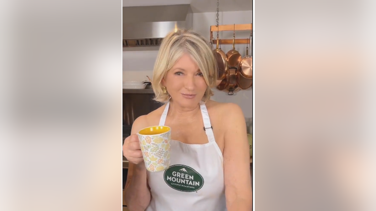 Martha Stewart dressed only apron while carrying a cup of coffee