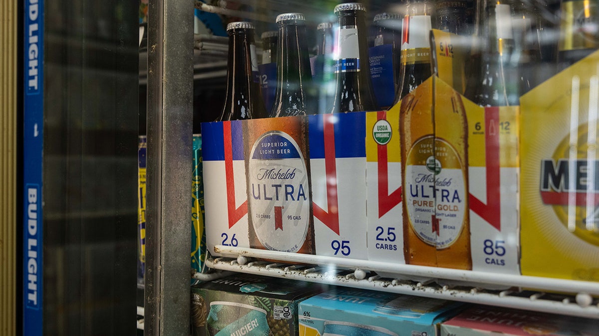Six-packs of Michelob Ultra and Michelob Ultra Pure Gold bottles seen in beer fridge.
