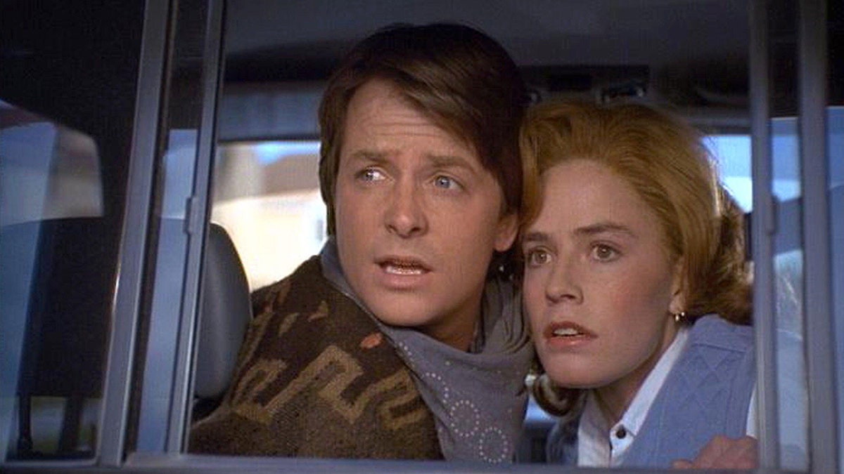 Michael J. Fox and Elisabeth Shue looking surprised inside a car.