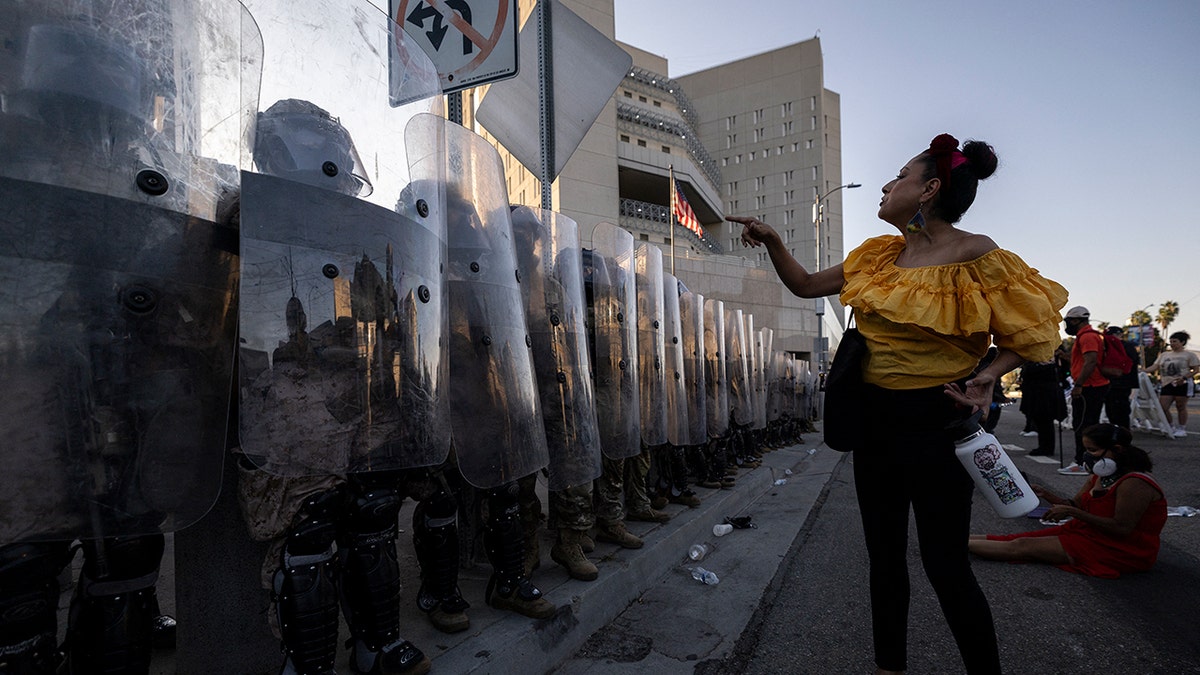 Protester angrily points at National Guard shield line