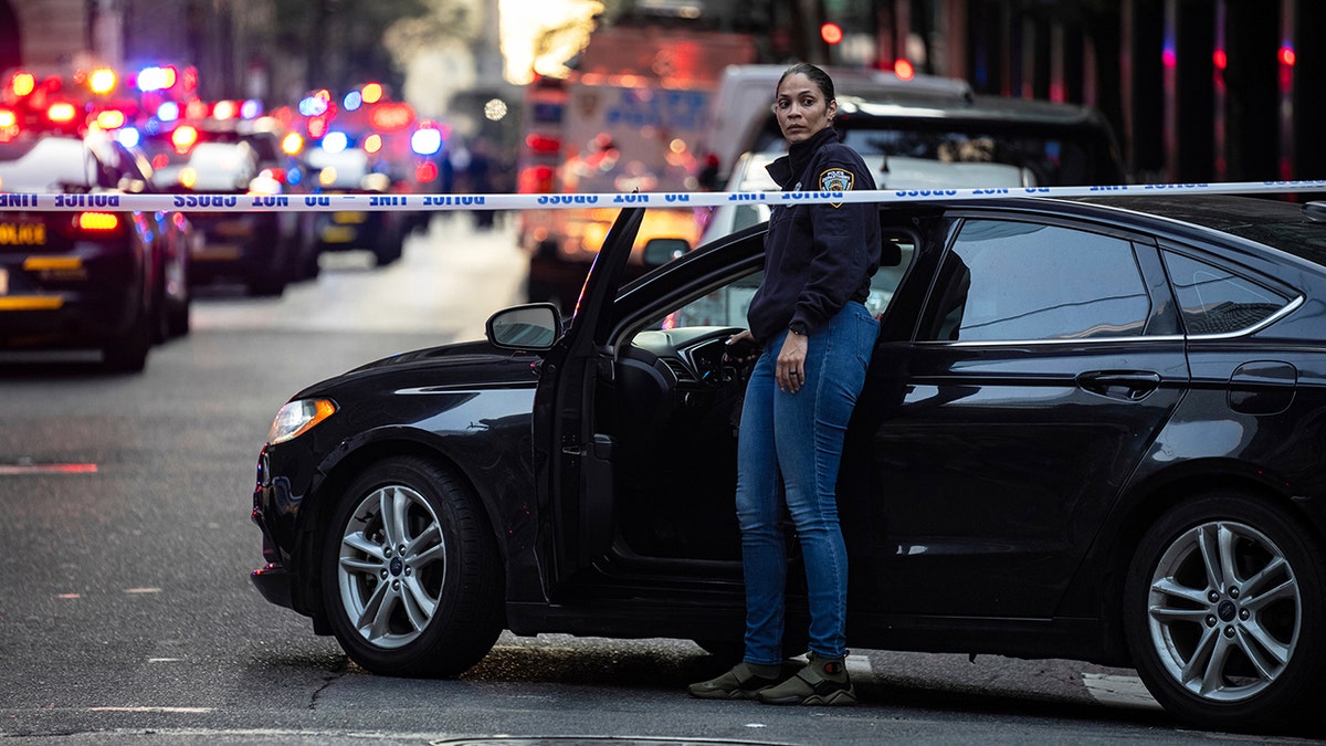NYPD officer standing by car