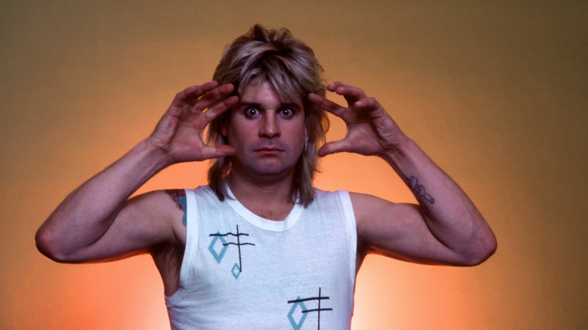 奧茲·奧斯本(Ozzy Osbourne)在橙色背景前擺姿勢