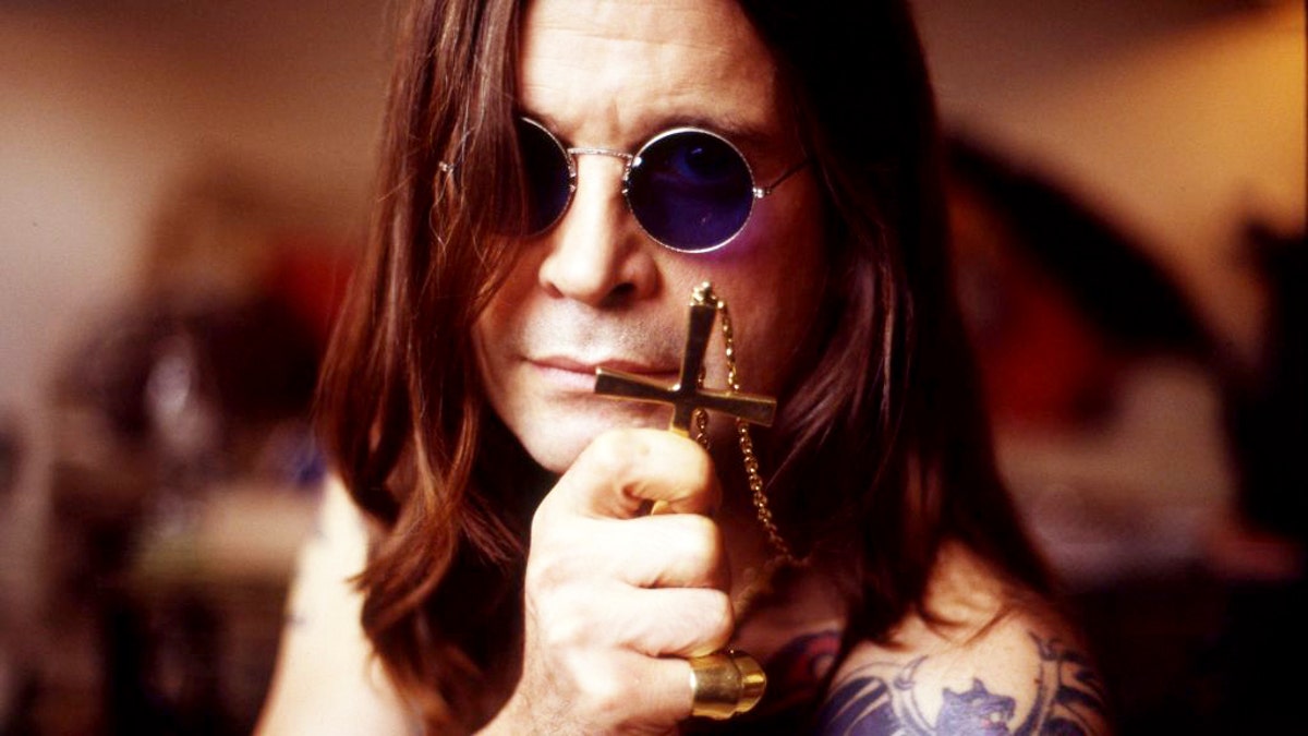 Ozzy Osbourne holding cross