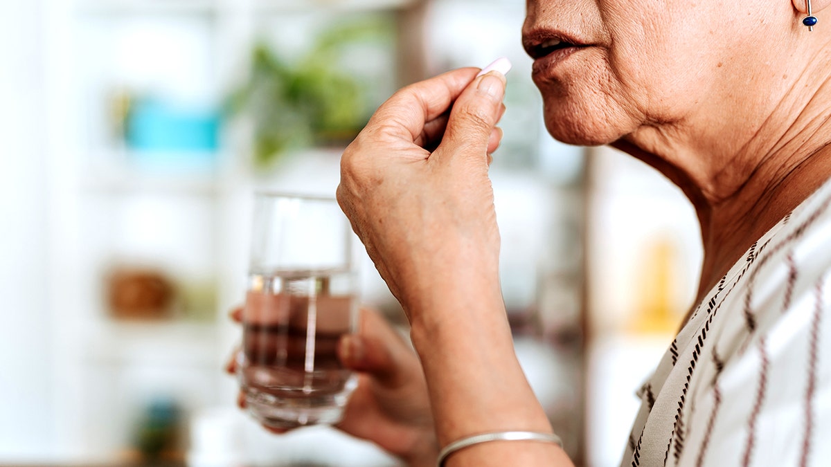 Older woman taking pill