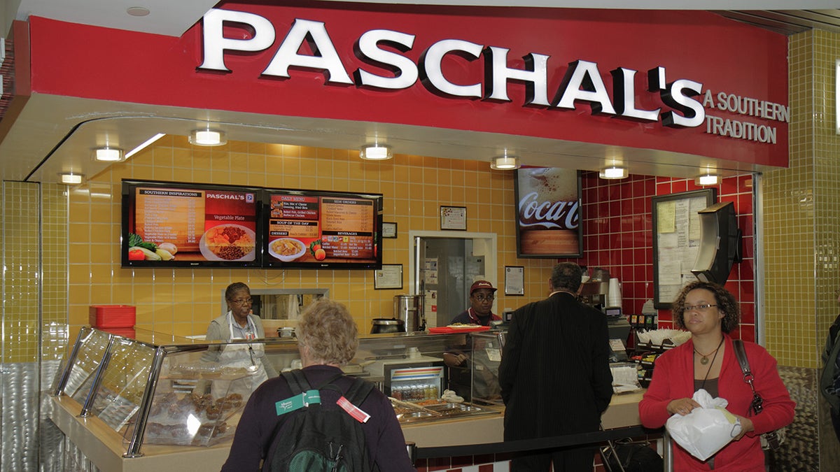 Paschal's Southern Comfort pārtikas restorāns, kas redzams Atl lidostā kopā ar darbiniekiem un klientiem