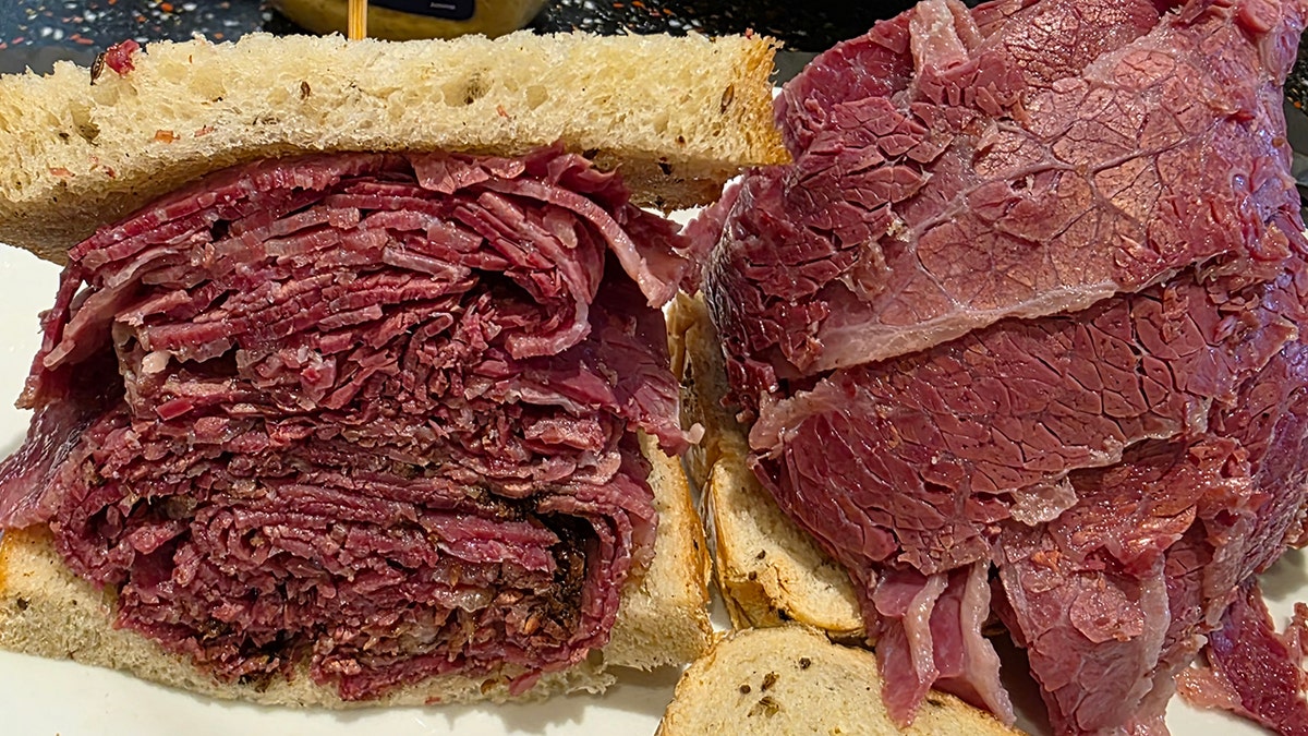 A pastrami sandwich on rye bread is shown.