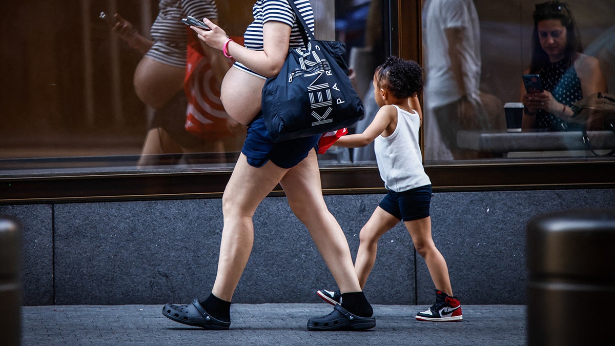 Pregnant woman walks down NYC street