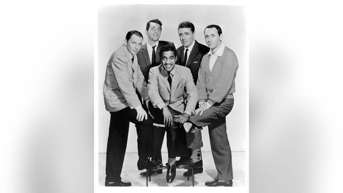 The Rat Pack posing together in matching suits.