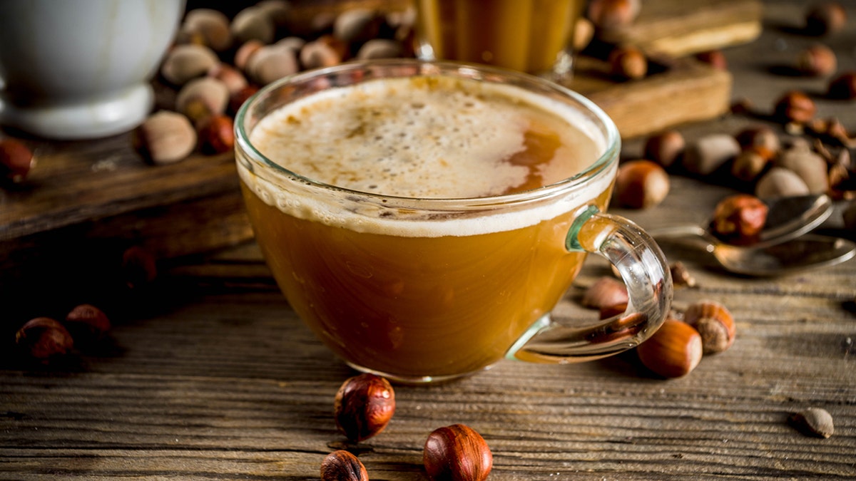 Cup of coffee next to hazelnuts