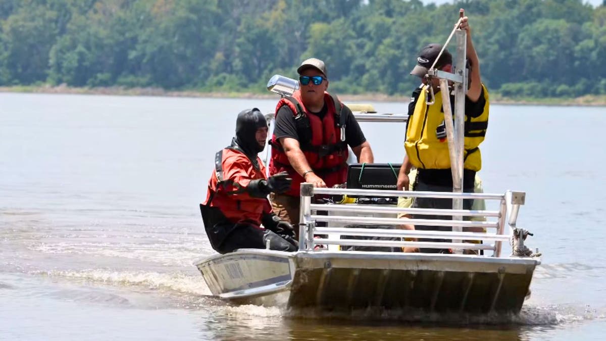 Three rescue men in a small boat