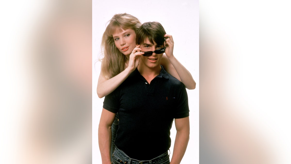 Rebecca De Mornay adjusting Tom Cruise's sunglasses.