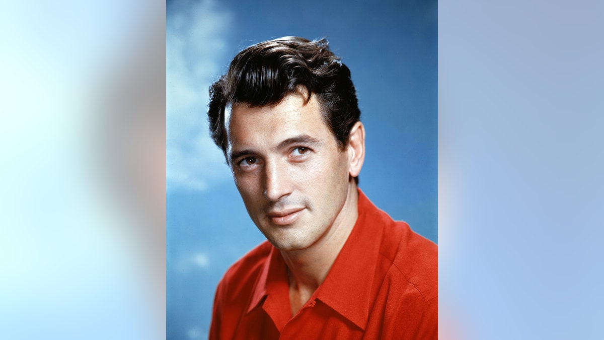 A close-up of Rock Hudson wearing a red collared shirt.