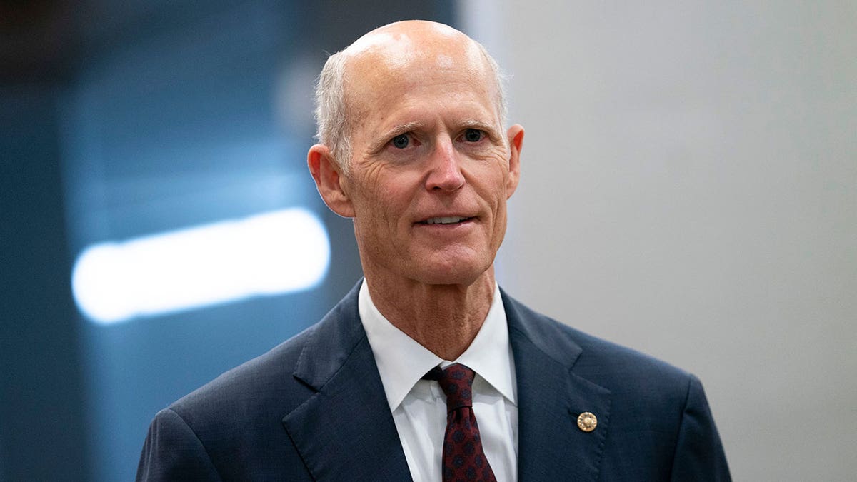 Senator Rick Scott smiling in dark suit
