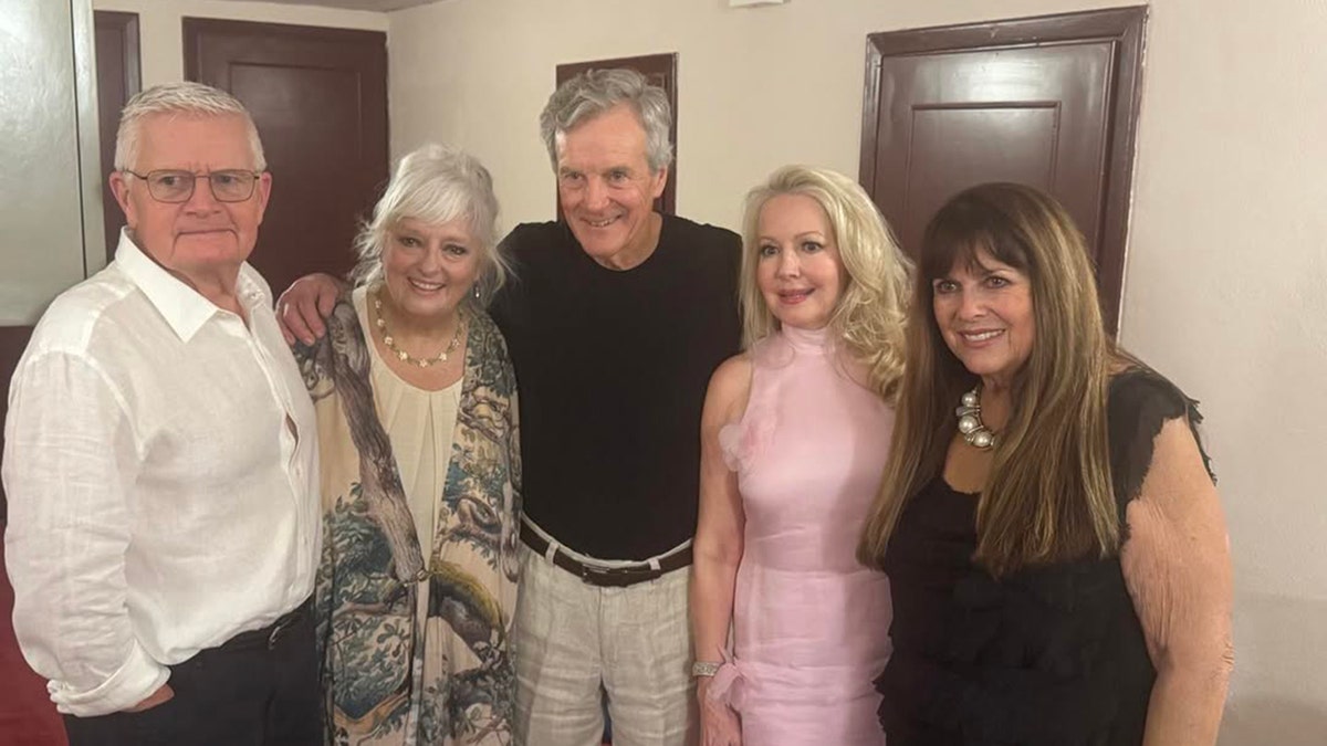 El elenco del sonido de la música posando y sonriendo en una foto grupal.