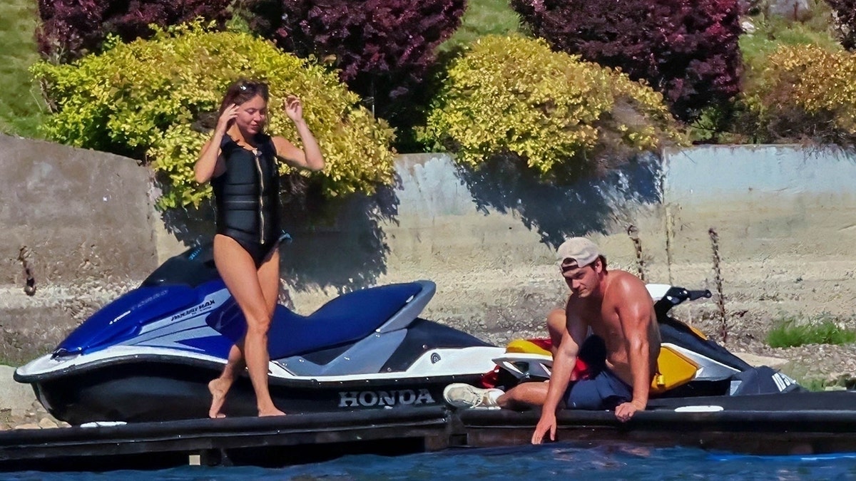 Sydney Sweeney wears a black life vest and matching bathing suit.
