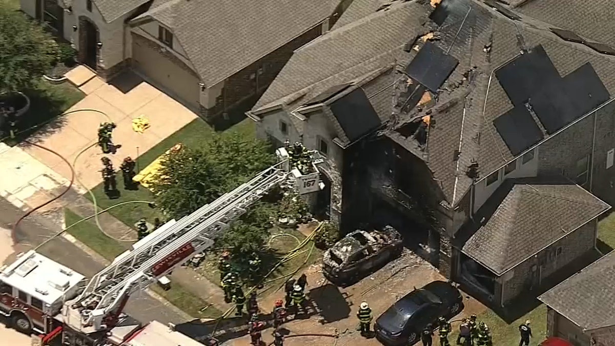 Firefighters tend to a house that was burned from a massive fire