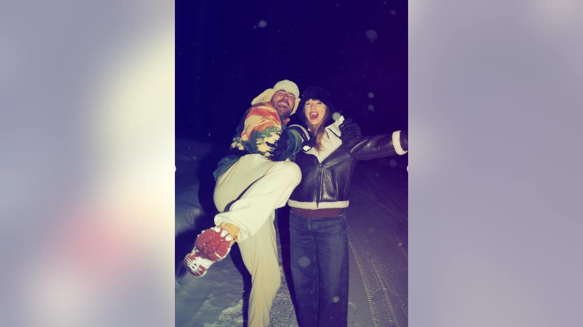Taylor Swift and Travis Kelce posing in the snow