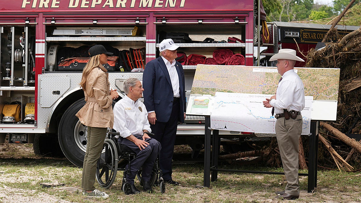 First lady Melania Trump, President Donald Trump and Texas Gov. Greg Abbott are briefed on the flood devastation in Kerrville, Texas, Friday.