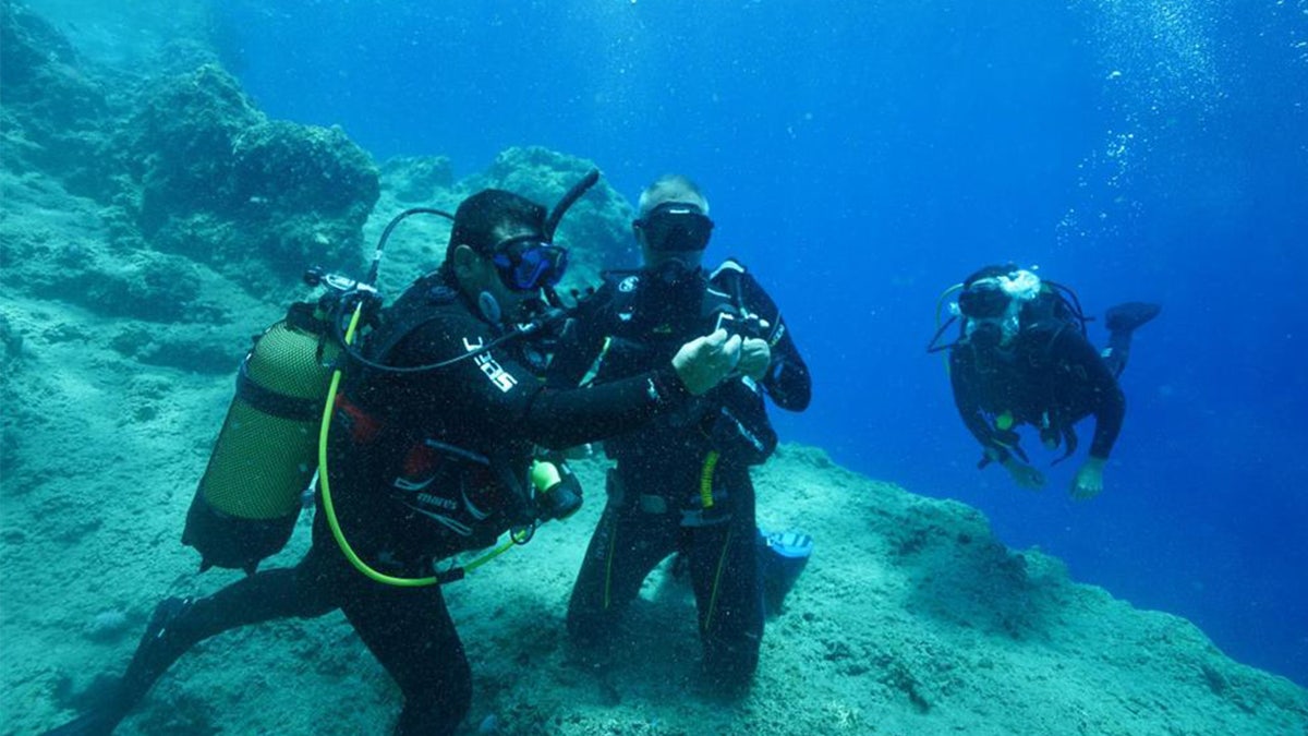 Divers inspecting artifacts in sea