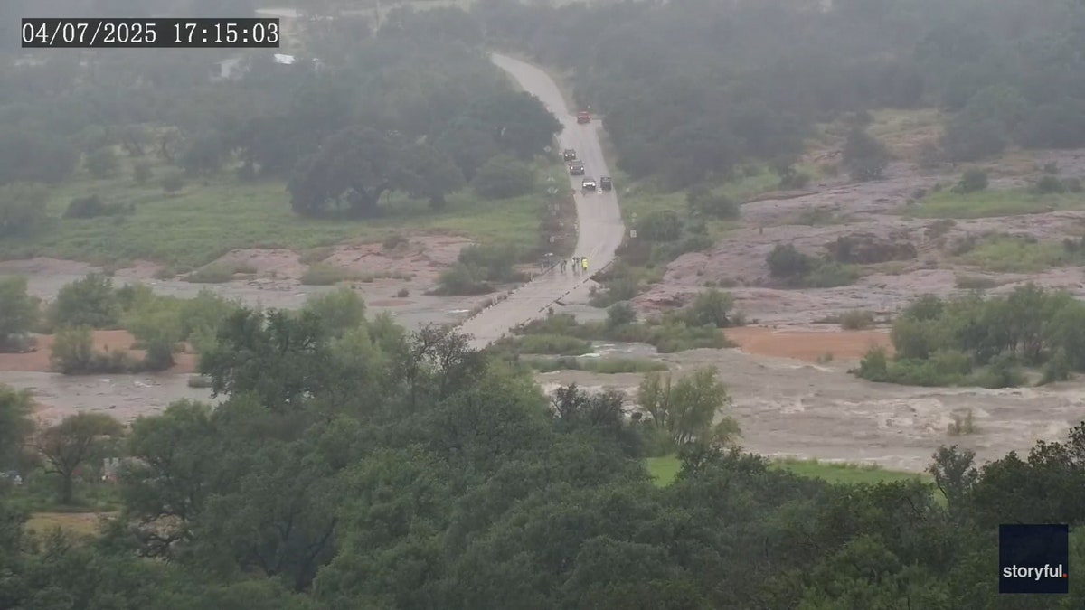 floodwaters begin overtaking small road