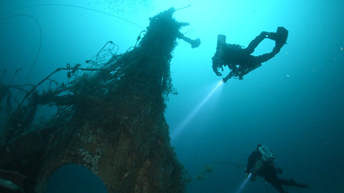 Image of crew looking at shipwreck from below