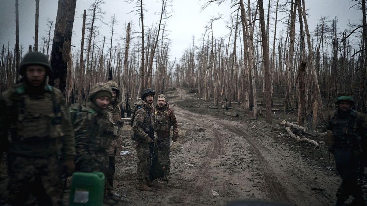 Ukrainian soldiers stand in destroyed Luhansk region.