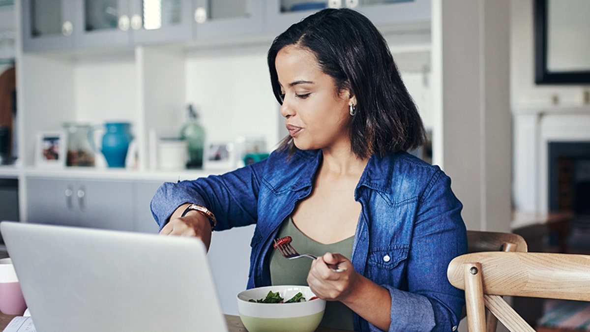 woman checking her watch while eating at home