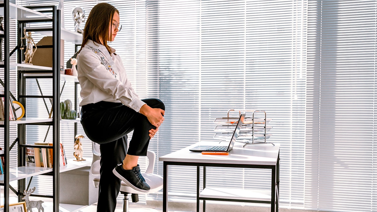 Woman stretching while working at office