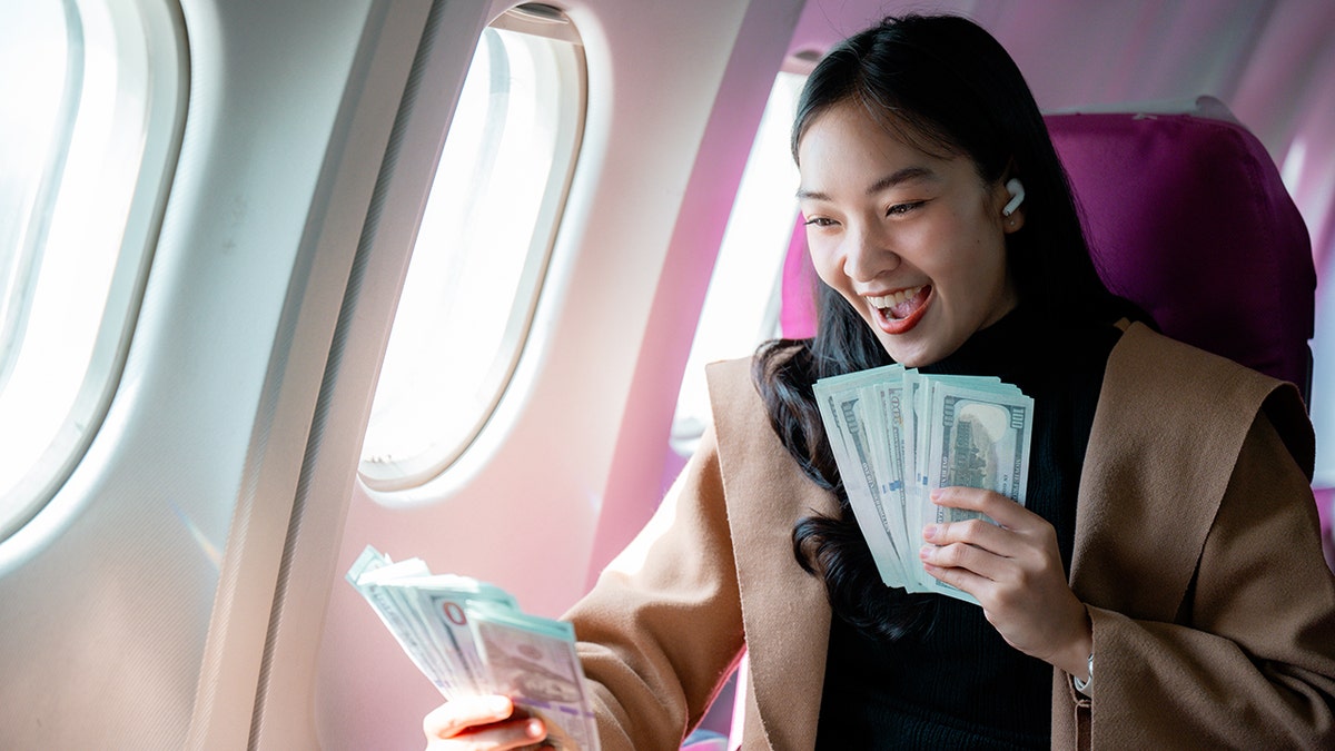 Successful businesswomen celebrate financial achievements, embrace cash with joy during their plane trips, expressing professional victory