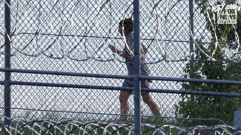 Ghislaine Maxwell is seen behind razor wire in prison