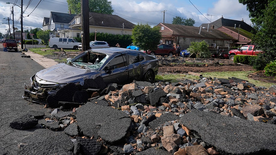 A damaged car with rubble in front of it