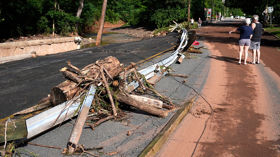 People on the side of the road observing damage after a flood