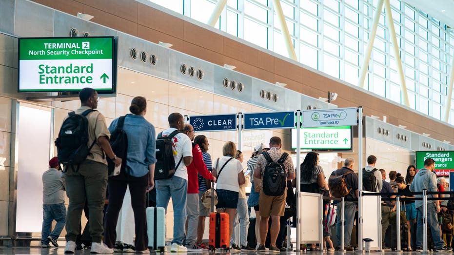 Travelers wait to go through security in the TSA PreCheck line at Ronald Reagan Washington National Airport (DCA) in Arlington, Virginia, US, on Thursday, July 3, 2025.