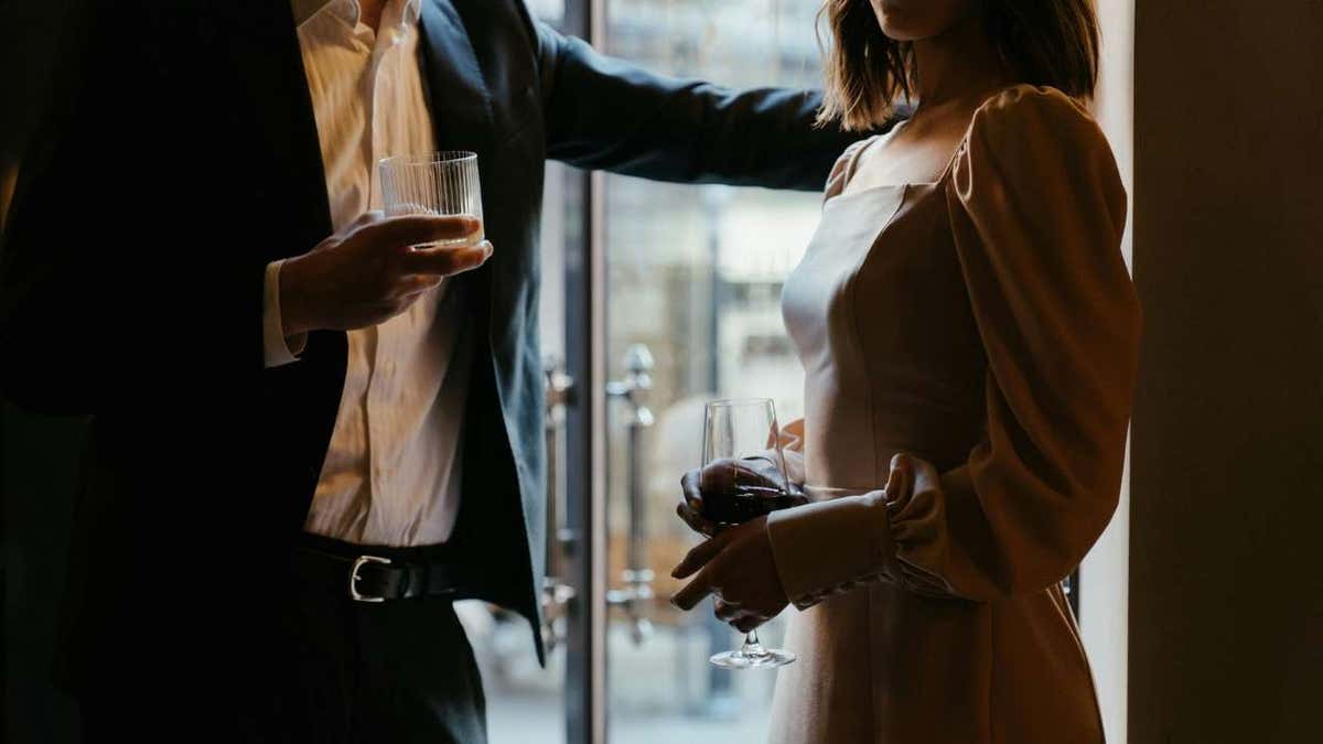 A man and a woman drink drinks in a restaurant.