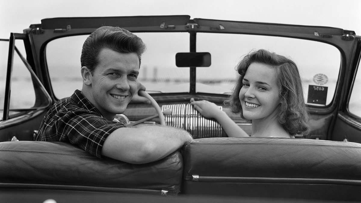 Teenage couple sitting in convertible car in October 1941.