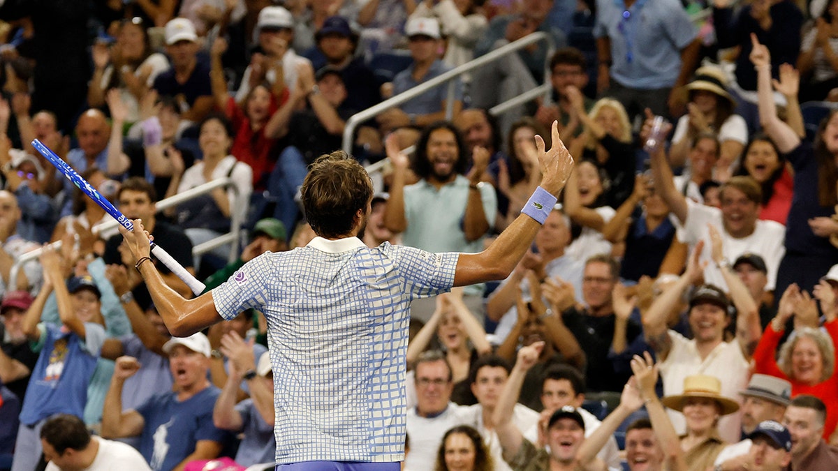 U.S. Open tennis fans cheer on a player during a match.