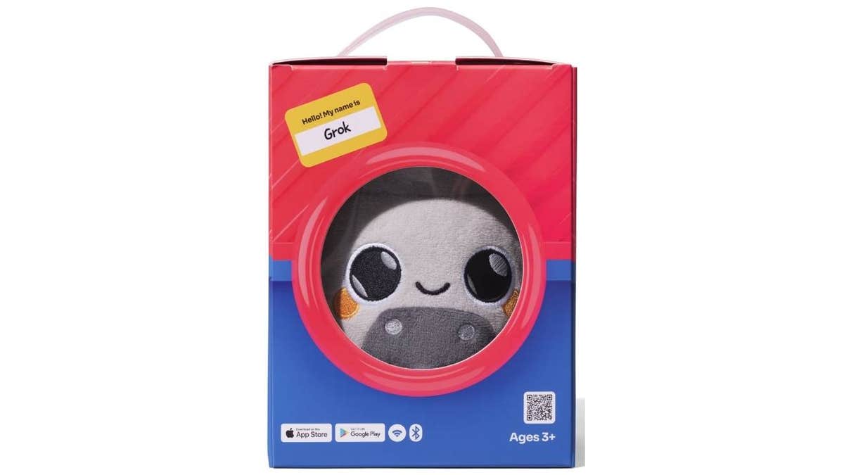 cute grey stauffed animal in box with label name Grok