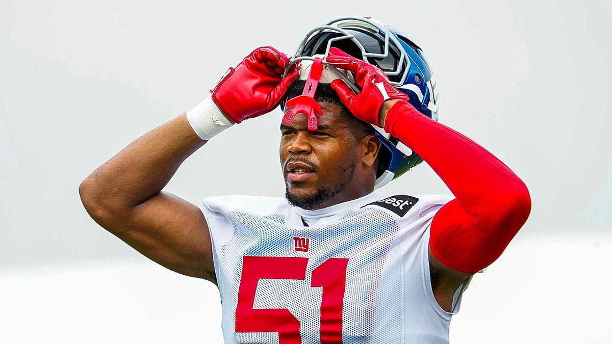 Abdul Carter puts helmet on at practice