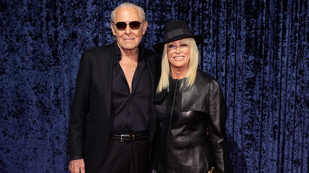 Alan Hamel and Suzanne Somers wearing matching black attire at Clive Davis 90th birthday celebration.