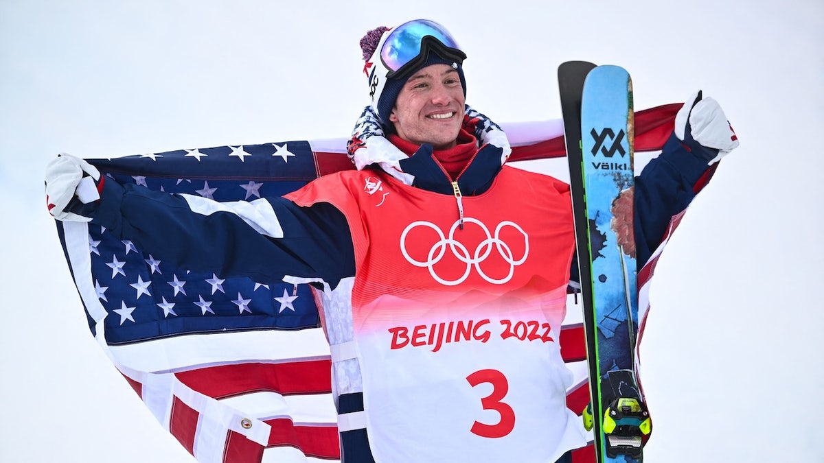 Bronze medallist USA's Alex Ferreira poses with his national flag on the podium during a venue ceremony after the freestyle skiing men's freeski halfpipe final run during the Beijing 2022 Winter Olympic Games at the Genting Snow Park H&S Stadium in Zhangjiakou on February 19, 2022.